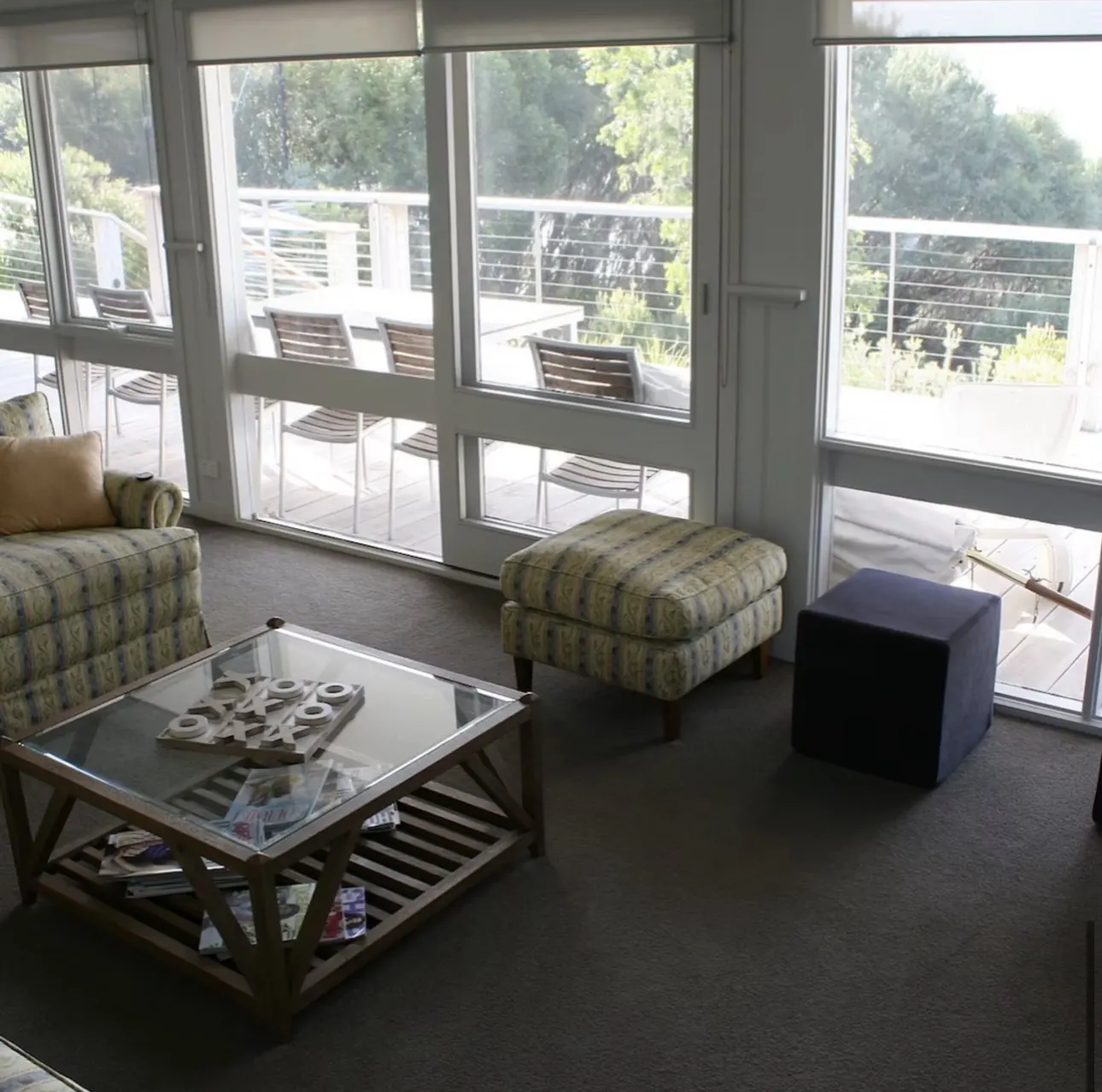 Light-filled sitting area with floor to ceiling windows opening to the deck