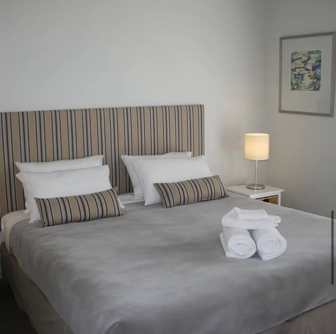 Suite 1 with king bed, crisp white linen and fresh towels at The Waterfront Loch Sport