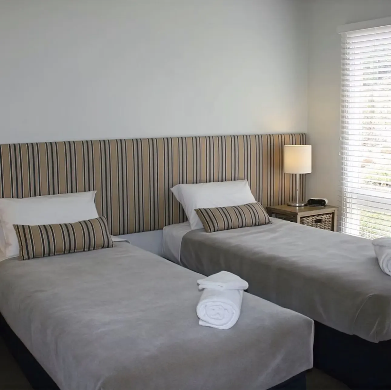 Suite 2 set up with two king single beds and bedside lamp
