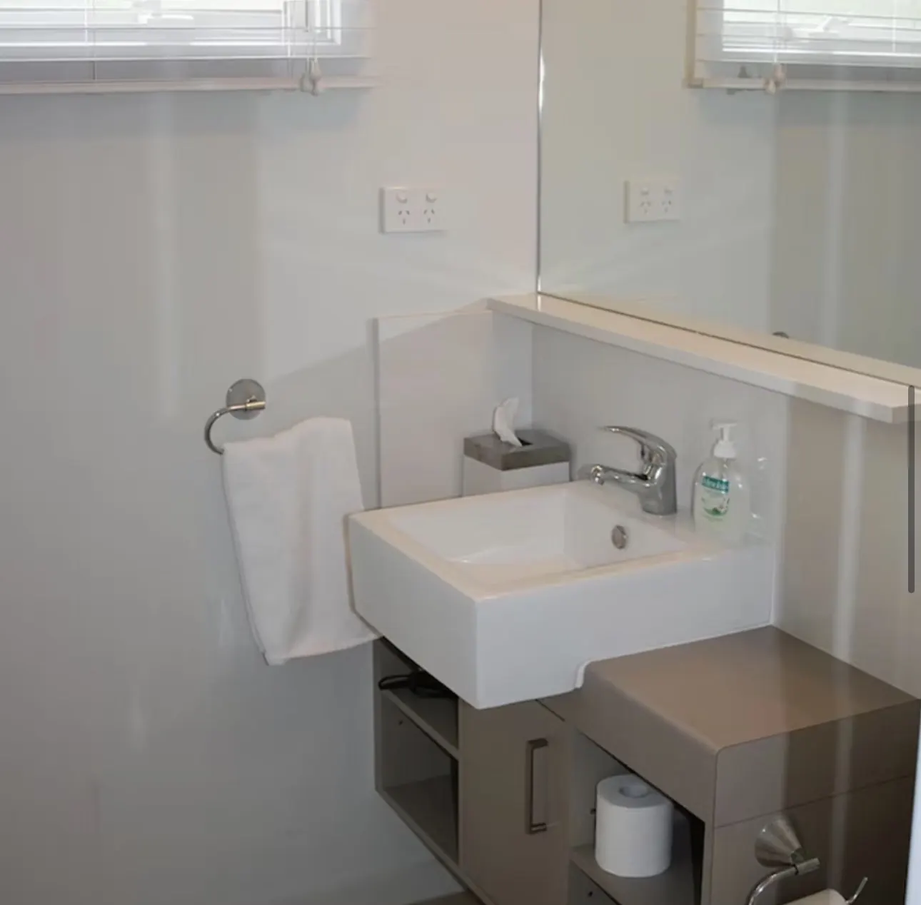 Powder room with basin, mirror and fresh white towel